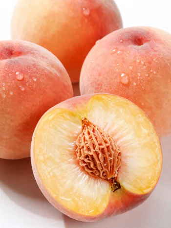 Đào tươi chín mọng cắt lát và nguyên quả trên bàn gỗ