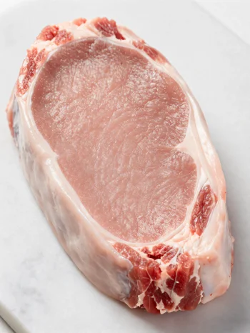 Thịt bê tươi màu hồng nhạt cùng gia vị trên thớt gỗ