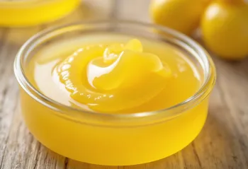 Hũ Ghee vàng óng và thìa gỗ múc bơ trên bàn