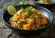 Chảo wok đầy ắp bí đỏ, quinoa và đậu phụ sốt cà ri hấp dẫn.